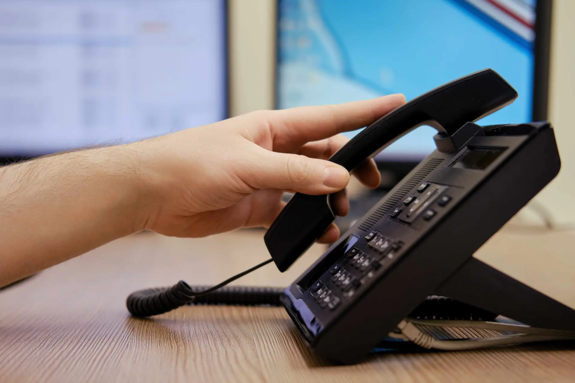 A person in an office picks up the phone.