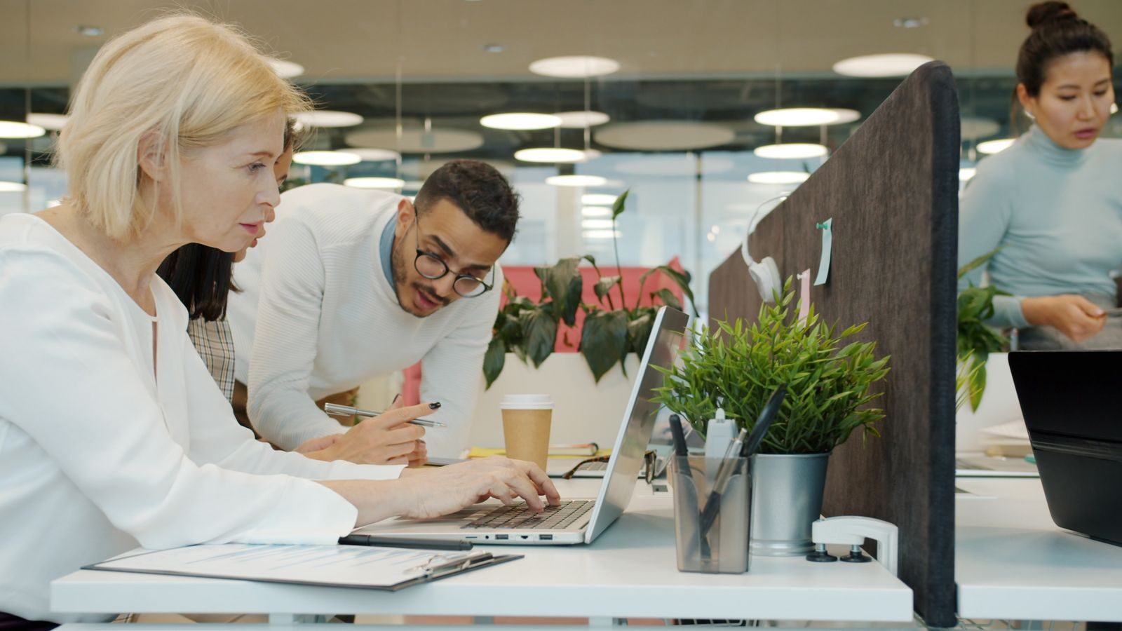 Group of diverse professionals collaborating at a modern office workspace.